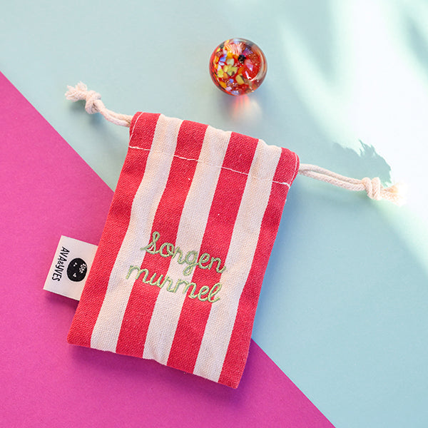 Kraftmurmel aus Muranoglas (Rot mit Konfetti-Steinchen) 25mm, in hochwertigem Stoffbeutel mit Stickerei