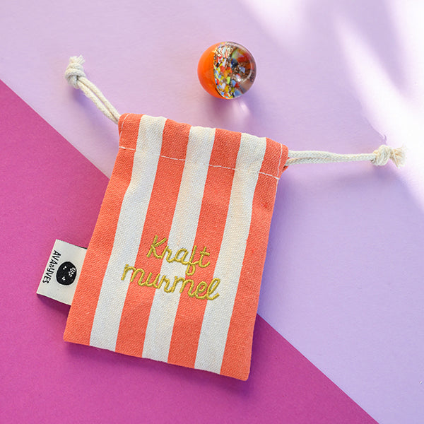 Kraftmurmel aus Muranoglas (orange mit Konfetti-Steinchen) 25mm, in hochwertigem Stoffbeutel mit Stickerei